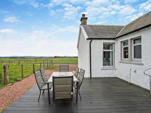 a wooden deck with a table and chairs on a house at 2 Bed in Carluke oc-95359 in Carluke