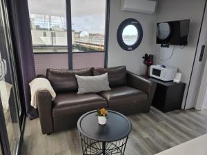 a living room with a leather couch and a table at Fjord Lyckholm in Schleswig