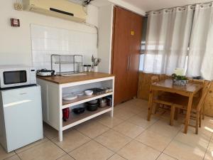 a small kitchen with a table and a microwave at Little Prince Hostel-5 Min Walk To The Beach in Eilat +26 photos