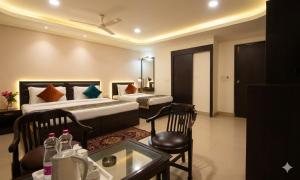 a hotel room with two beds and a table at HOTEL DAKHA INTERNATIONAL - Karol Bagh, New Delhi in New Delhi