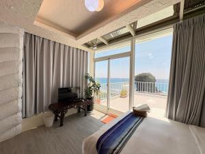 a bedroom with a bed and a view of the ocean at Ming Jun Homestay in Eluan