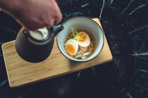 a person pouring eggs into a bowl of food at Leonardo Hotel Papendrecht in Papendrecht +43 photos
