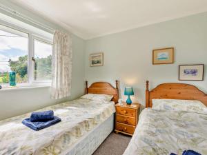 a bedroom with two beds and a window at 3 Bed in Keswick oc-sz047 in Threlkeld