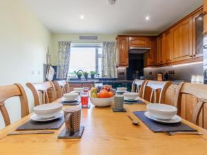 a kitchen with a wooden table with a bowl of fruit at 3 Bed in Dumfries oc-77430 in Auldgirth +17 photos