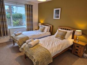 a bedroom with two beds and a window at 3 Bed in Dumfries oc-77430 in Auldgirth
