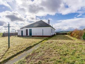 a white building with a pole in a field at 3 Bed in Dumfries oc-77430 in Auldgirth