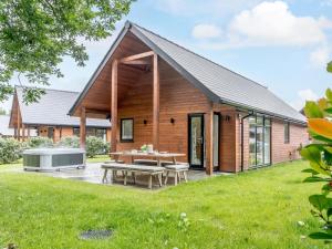a wooden house with a picnic table and a hot tub at 2 Bed in Swansea oc-91725 in Killay