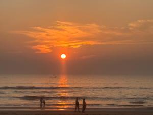 people standing on the beach watching the sunset at Gokarna Beach Vibes in Gokarn