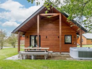 a log cabin with a picnic table and a hot tub at 2 Bed in Swansea oc-91726 in Killay