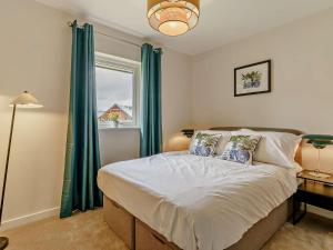 a bedroom with a bed with green curtains and a window at 2 Bed in Swansea oc-91726 in Killay