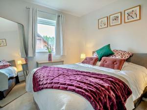 a bedroom with a large bed with a purple blanket at 3 Bed in Swansea oc-91721 in Killay +13 photos