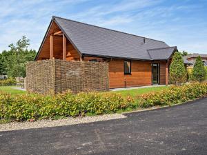 a large wooden house with a black roof at 3 Bed in Swansea oc-91721 in Killay