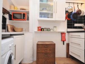 a small kitchen with white cabinets and a washer and dryer at 3 Bed in Kingsbridge oc-75138 in Bigbury