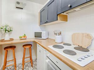a kitchen with a stove and a counter with stools at 2 Bed in Keswick oc-91901 in Keswick