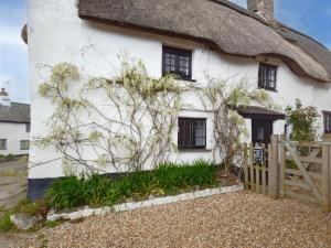 a thatched cottage with a fence in front of it at 3 Bed in Kingsbridge oc-75138 in Bigbury