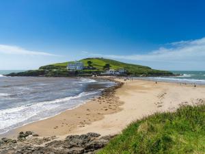 a beach with people walking on the sand and the ocean at 3 Bed in Kingsbridge oc-75138 in Bigbury +10 photos