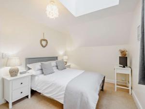 a white bedroom with a bed and a tv at 2 Bed in Keswick oc-91901 in Keswick +4 photos