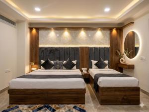 a bedroom with two beds and a mirror at HOTEL DAKHA INTERNATIONAL - Karol Bagh, New Delhi in New Delhi