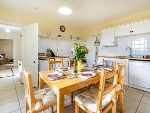 a kitchen and dining room with a wooden table and chairs at 3 Bed in Archiestown oc-ca227 in Carron