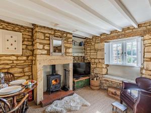 a living room with a stone wall with a fireplace at 1 Bed in Chipping Campden oc-93393 in Chipping Campden