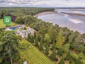 an aerial view of a house with trees and a beach at 1 Bed in Forres oc-78430 in Forres