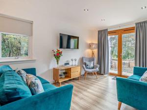 a living room with a blue couch and a table at 3 Bed in Callander oc-79359 in Callander