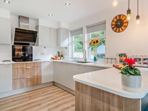 a kitchen with white cabinets and a clock on the wall at 3 Bed in Callander oc-79359 in Callander