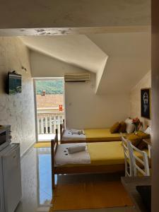 a bedroom with two beds and a window at Apartmani Gušti in Kamenari