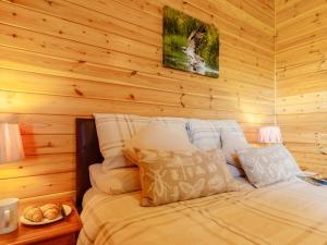 a bed in a room with a wooden wall at 2 Bed in Kinross oc-82297 in Kinross