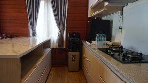 a kitchen with a stove and a counter top at Lembah Indah Malang in Gendogo +20 photos