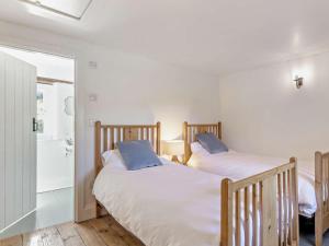 two twin beds in a room with a bathroom at 4 Bed in Leyburn oc-g0008 in Gammersgill