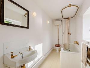 a white bathroom with a sink and a mirror at 4 Bed in Leyburn oc-g0008 in Gammersgill +18 photos
