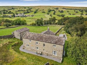 an aerial view of an old stone house in a field at 4 Bed in Leyburn oc-g0008 in Gammersgill
