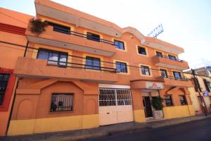 um edifício laranja com uma varanda numa rua em Hotel Isabel I em Oaxaca de Juárez