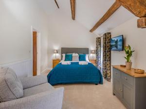 a bedroom with a blue bed and a couch at 1 Bed in Grange-over-sands oc-78659 in Cartmel