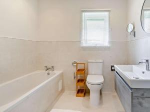 a bathroom with a tub and a toilet and a sink at 3 Bed in Swansea oc-91729 in Killay