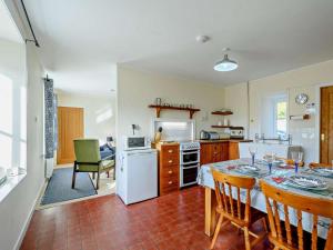 a kitchen with a table and a white refrigerator at 2 Bed in Strontian oc-ca046 in Scotstown
