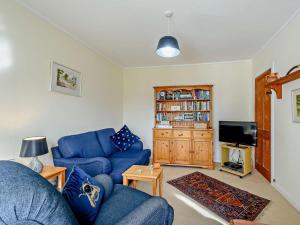 a living room with a blue couch and a tv at 2 Bed in Strontian oc-ca046 in Scotstown