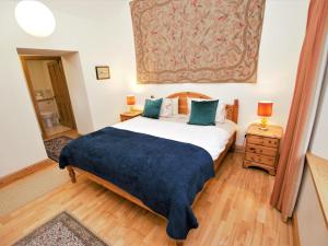 a bedroom with a large bed with a blue blanket at 2 Bed in Lochgilphead oc-ca113 in Cairnbaan