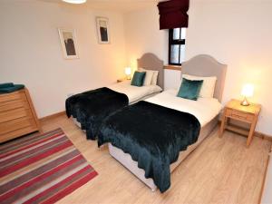 two beds in a hotel room with black covers at 1 Bed in Lochgilphead oc-ca304 in Lochgilphead
