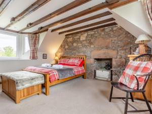 a bedroom with a bed and a stone wall at 2 Bed in Drumnadrochit oc-ca315 in Drumnadrochit