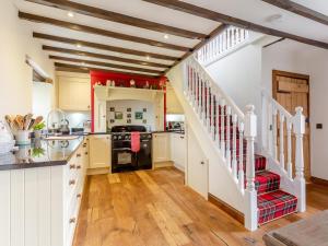 a kitchen with wooden floors and white walls and a staircase at 2 Bed in Drumnadrochit oc-ca315 in Drumnadrochit