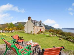 two chairs and a table in front of a house at 2 Bed in Drumnadrochit oc-ca315 in Drumnadrochit