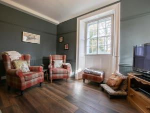 a living room with chairs and a flat screen tv at 3 Bed in Penrith oc-74159 in Shap