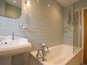 a bathroom with a tub and a sink and a shower at 3 Bed in Penrith oc-74159 in Shap +19 photos