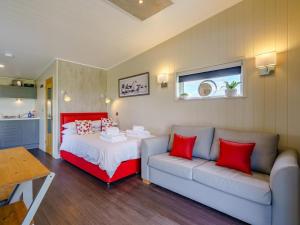 a bedroom with a couch and a bed with red pillows at 1 Bed in Girvan oc-78071 in Girvan