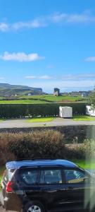 a black car parked on the side of a road at Dubhlinn House Accommodation in Doolin +5 photos