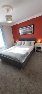 a bedroom with a large bed with a red wall at Dubhlinn House Accommodation in Doolin