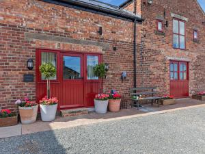 a brick building with a red door and some potted plants at 1 Bed in Gateshead oc-95877 in Lamesley