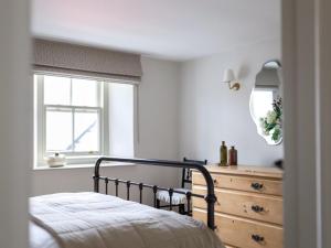 a bedroom with a bed and a dresser and a mirror at 1 Bed in Sedbergh oc-g0182 in Milnthorpe